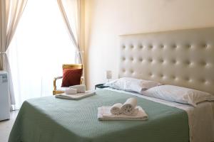 a bedroom with a bed with two towels on it at Landolina Palace Hotel in Noto