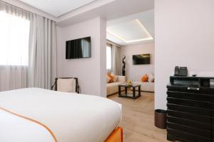 a bedroom with a bed and a living room at Occidental Casablanca Medina in Casablanca
