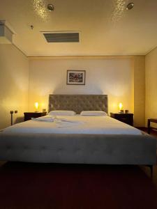 a bedroom with a large bed with two night stands at Europa Grand Vlora in Vlorë