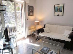 a living room with a couch and a glass table at Studio charmant à Villers-sur-Mer avec terrasse - 33 m² in Villers-sur-Mer