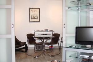 a dining room with a table and chairs and a television at Studio charmant à Villers-sur-Mer avec terrasse - 33 m² in Villers-sur-Mer