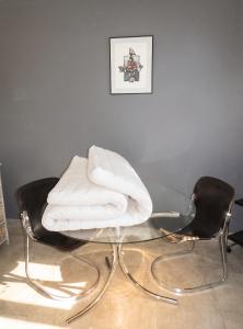 a glass table with two chairs with white towels on it at Studio charmant à Villers-sur-Mer avec terrasse - 33 m² in Villers-sur-Mer