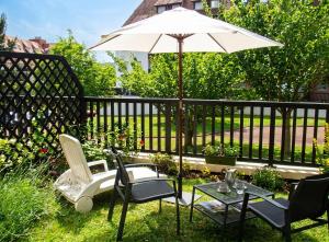 a patio with a table and chairs and an umbrella at Studio charmant à Villers-sur-Mer avec terrasse - 33 m² in Villers-sur-Mer