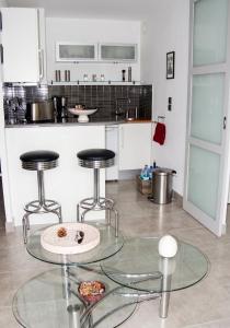 a kitchen with two stools and a glass table at Studio charmant à Villers-sur-Mer avec terrasse - 33 m² in Villers-sur-Mer +11 photos