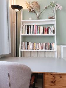 a white book shelf filled with dvds at Studio accueillant au cœur de Paris - 30 m² - Tout inclus. in Paris