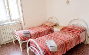 two beds sitting next to each other in a bedroom at Spacious Apartment in Pescara, 120 m², Ideal for Families in Pescara