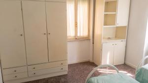 a bedroom with white cabinets and a window at Spacious Apartment in Pescara, 120 m², Ideal for Families in Pescara