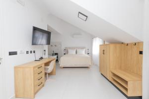 a white bedroom with a bed and a desk at Apartments ANA Karlobag in Karlobag