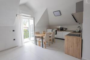 a kitchen and dining room with a table and chairs at Apartments ANA Karlobag in Karlobag