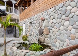 a stone wall with a fountain in front of a building at Appartement charmant à Lamentin avec piscine partagée in Lamentin