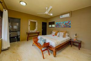 a bedroom with a bed and a ceiling fan at Villas des Alizes Beachfront Suites in Grand'Anse Praslin