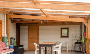 a wooden pergola on a patio with a table at Charmante maison avec piscine privée à Orsanco - 70 m² in Orsanco