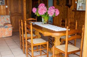 a wooden table with chairs and a vase of flowers at Charmante maison avec piscine privée à Orsanco - 70 m² in Orsanco