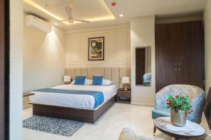 a hotel room with a bed and a chair at The Grand Dularia in Nagpur