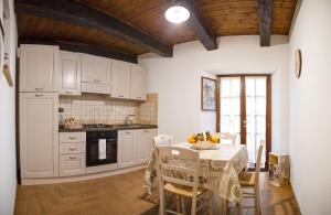 a kitchen with white cabinets and a table with chairs at Modern Apartment near Arce City Centre, 62 m², Parking in Arce