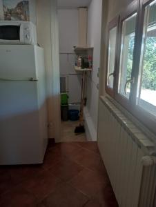 a kitchen with a white refrigerator and a window at La Chênaie Gîte in Sampzon +10 photos