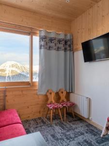 a living room with a couch and a window at Studio chaleureux à Aime la Plagne 25 m² en montagne in Aime-La Plagne