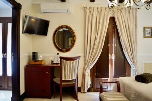 a bedroom with a bed and a desk and a mirror at Hotel Boutique Casa Veracruz in Estepona