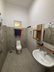a bathroom with a white toilet and a sink at Lobster Inn in Trincomalee +84 photos