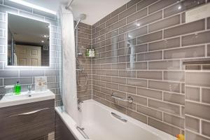 a bathroom with a tub and a sink and a mirror at The Royal Oak Hotel, Welshpool - The Coaching Inn Group in Welshpool +60 photos