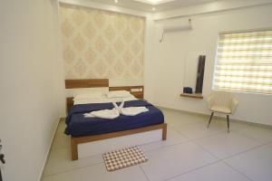 a bedroom with a blue bed and a chair at KPN Tower in Erāttupetta