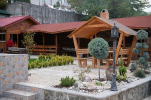 a wooden pavilion in a garden in front of a building at Vila Crinilor Căciulata in Căciulata