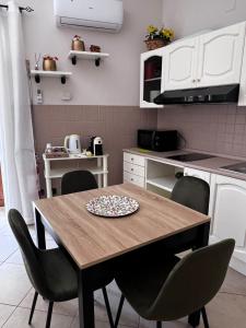 a kitchen with a wooden table and chairs at Nonna Croce Home in San Giovanni Gemini