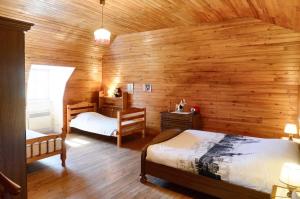 a bedroom with two beds and a wooden wall at Maison confortable avec vue sur la montagne à Le Fau in Le Fau