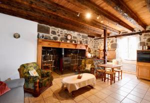 a living room with a fireplace and a table and chairs at Maison confortable avec vue sur la montagne à Le Fau in Le Fau