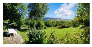 a garden with a table and chairs in a field at Maison confortable avec vue sur la montagne à Le Fau in Le Fau +4 photos