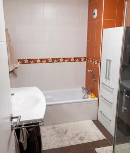 a bathroom with a sink and a bath tub at Appartement confortable à Apach avec balcon in Apach +4 photos