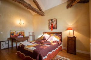 a bedroom with a bed and a table in a room at Appartement charmant à Castéra-Lectourois avec piscine partagée in Castéra-Lectourois