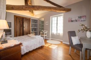 a bedroom with a bed and a desk and a window at Appartement charmant à Castéra-Lectourois avec piscine partagée in Castéra-Lectourois