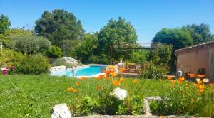 a garden with a swimming pool and flowers at Appartement charmant à Castéra-Lectourois avec piscine partagée in Castéra-Lectourois