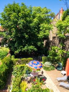 a patio with a table and an umbrella at Studio confort à Néris-les-Bains - 18 m² avec jardin in Néris-les-Bains