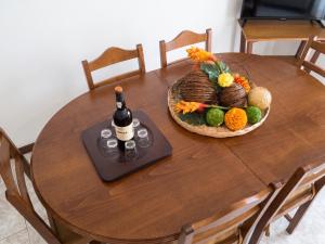 a table with a bottle of wine and a basket of fruit at Spacious Apartment in Espinho with Fireplace, 87 sqm in Espinho