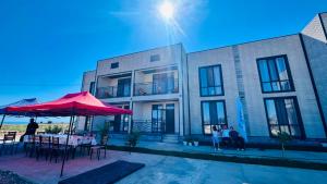 a building with a red umbrella and tables and chairs at Аска in Imeni Kirova