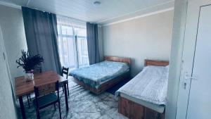 a bedroom with two beds and a desk and a table at Аска in Imeni Kirova