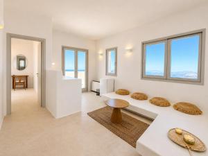 a living room with white walls and windows at Vespera Private Luxury Suites in Santorini
