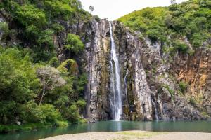 a waterfall on the side of a mountain with a lake at Studio confortable à Sainte-Suzanne, 20 m², balcon in Sainte-Suzanne +3 photos