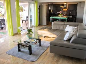 a living room with a couch and a table at Villa charmante à Le Tampon + Piscine in Le Tampon