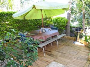 a patio with a table and an umbrella at Villa charmante à Le Tampon + Piscine in Le Tampon