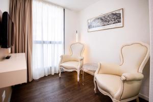 two chairs and a table in a room with a window at Hotel Muralto Locarno in Locarno +28 photos