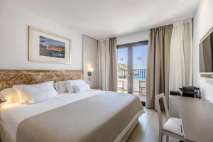 ein Hotelzimmer mit Bett und Balkon in der Unterkunft Hoposa Niu in Cala de Sant Vicent + 39 Fotos