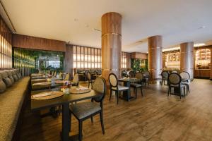 a restaurant with tables and chairs in a room at Occidental Casablanca Medina in Casablanca