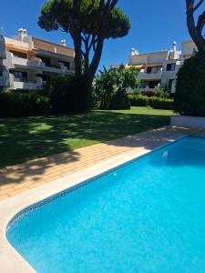 a swimming pool in front of a building at Solar Pinheiros RC in Vilamoura
