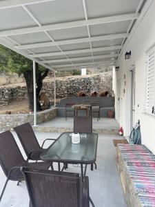 a patio with a table and chairs and a couch at Sykano Espace, Skyros Island in Skiros