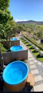 two hot tubs on a patio with benches around it at Revive Wellness Pods in Rostrevor +47 photos