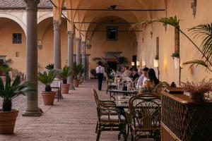 a group of people sitting at tables in a building at Hotel Certosa Di Maggiano in Siena