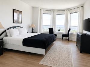 a bedroom with a bed and a television and windows at Seaview Executive Home in Ladysmith